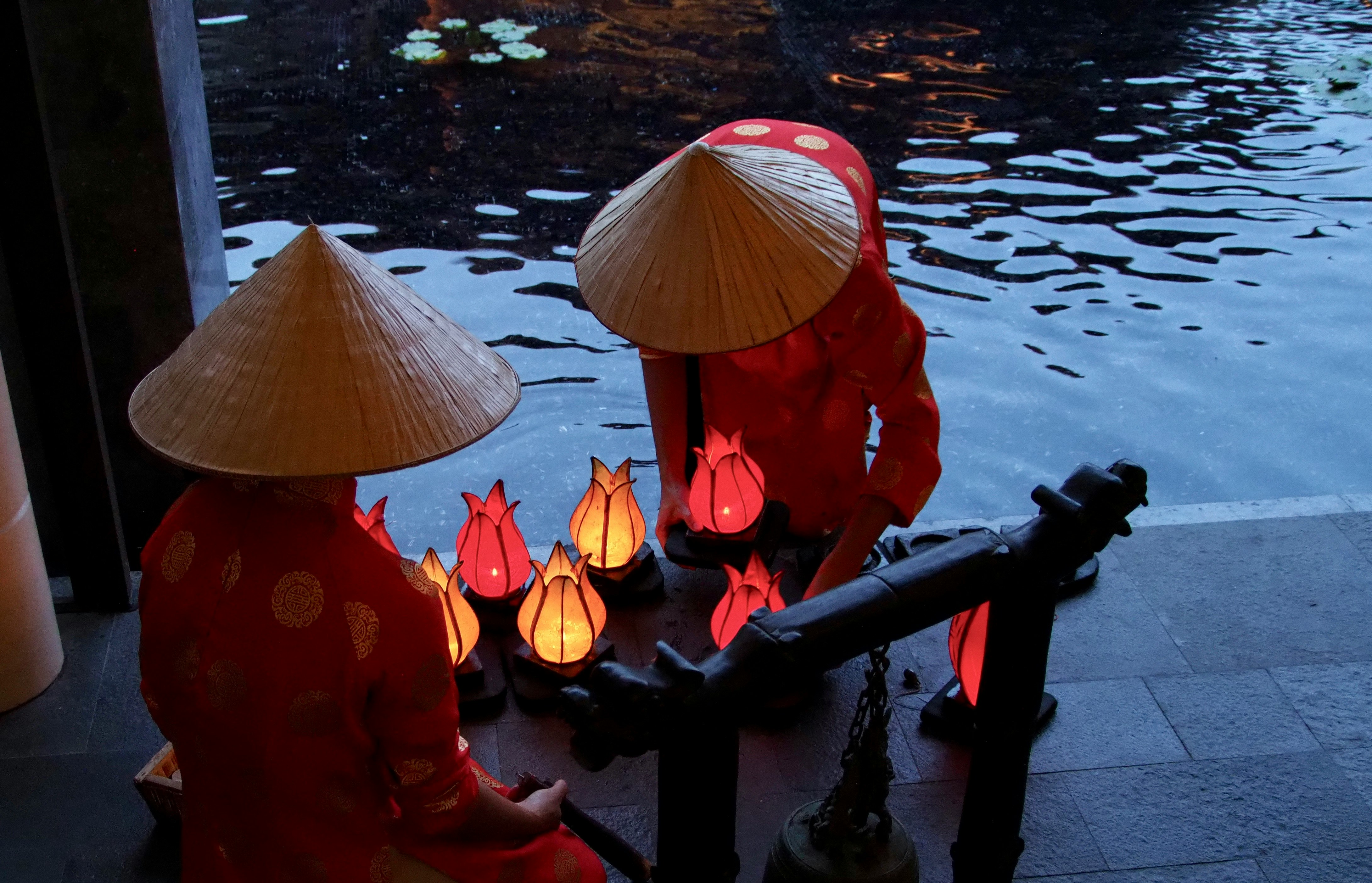 person in red dress holding umbrella standing on water